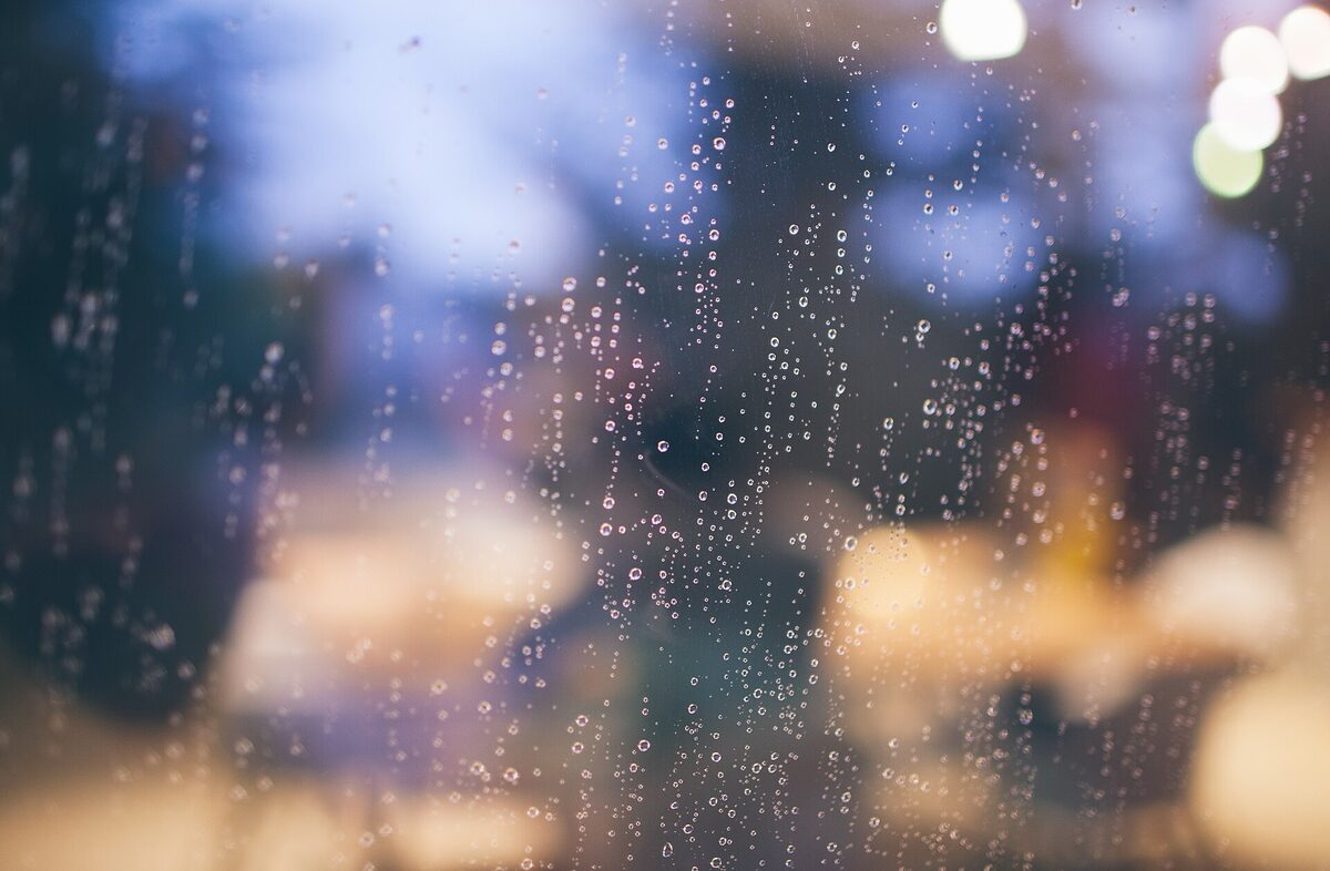 Raindrops on a window — closeness felt through the glass of distance.