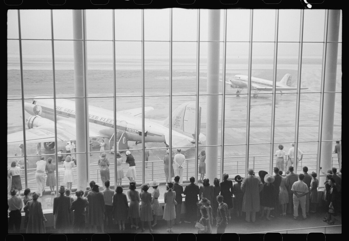An airport window at dusk — the texture of waiting and distance.