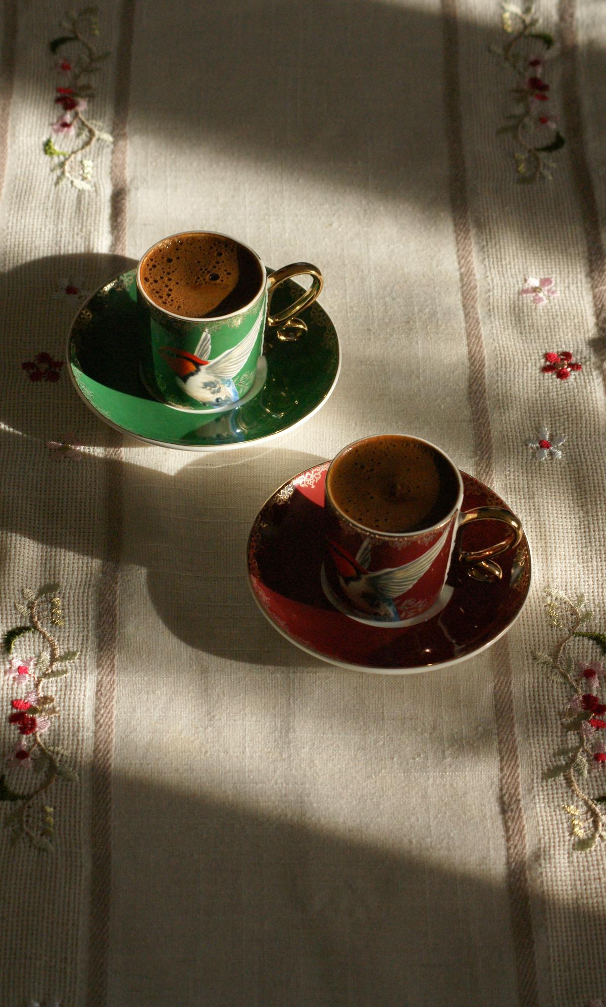 Two cups of Turkish coffee in golden hour light — a small thing worth paying for, shared by two people.
