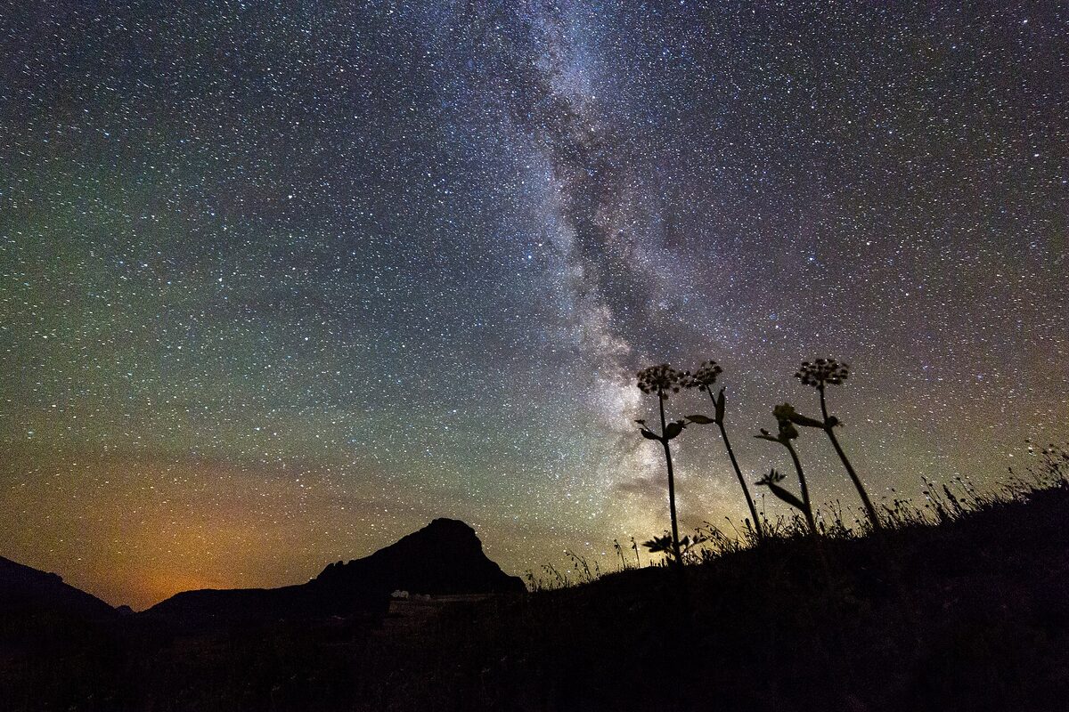 A star-filled night sky — the same sky over two very different hours.